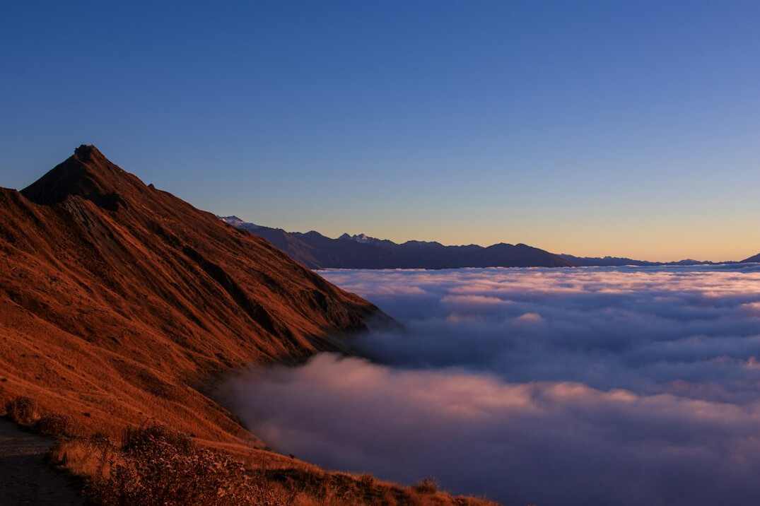 Mountain ridge above clouds at sunrise