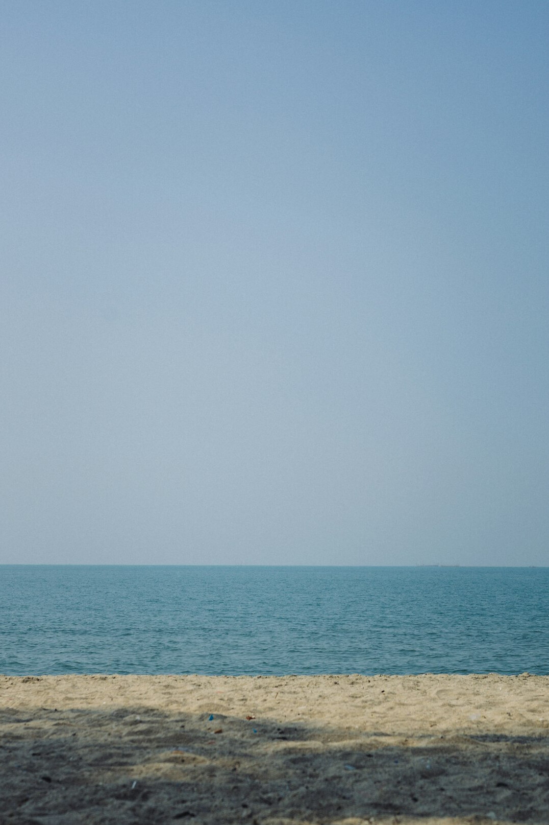Empty sandy beach with calm sea and clear sky